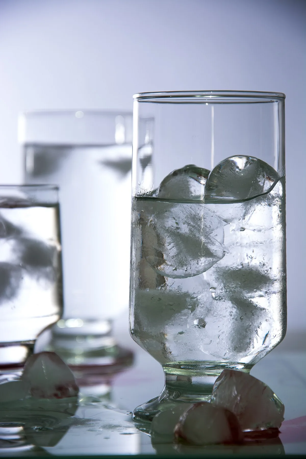 Glazen gevuld met water en ijsblokjes op een tafel